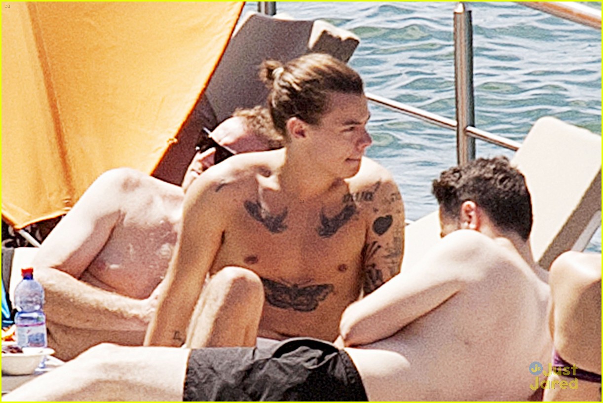 Harry Styles Rocks a Ponytail While Lounging Shirtless Poolside in Italy 